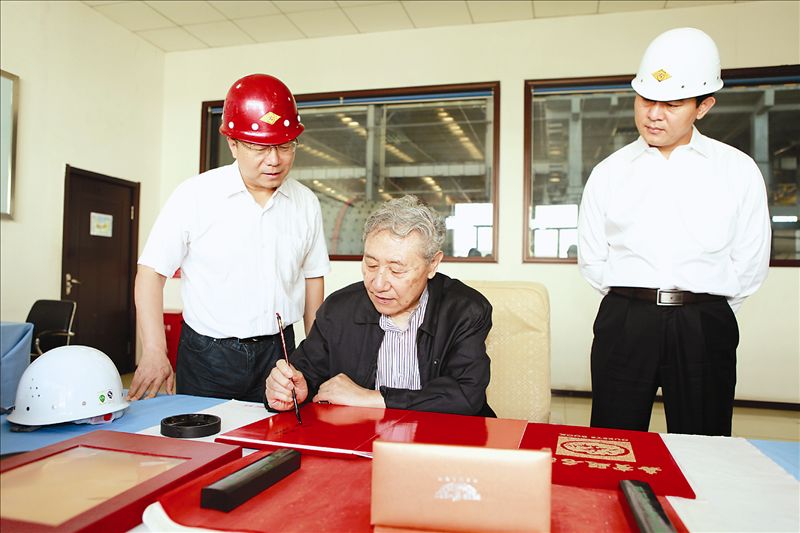 8月23日，中国科学院、工程院院士王淀佐又莅临乌山调研指导工作。内蒙古矿业公司董事长赵占国介绍了公司发展历程和生产经营情况。王淀佐院士表示，在参观了整个生产流程后，就铜钼分离工作，他提出要围绕四个方面反复实验：首先是合理配矿，通过对原矿物的研矿鉴定，弄清铜钼矿物的勘布情况，优化各种矿物的比例关系。其次是做好物相分析，研究磨矿后铜钼矿物的解离粒度，提高选矿效率。第三是弄清硫化钠在铜钼分离中的作用机理，并试验多种药剂，同时考虑浮铜抑钼与抑钼浮铜交替进行的可行性。第四是通过分析回水所含的各种离子对浮选的作用，再有针对性地进行回水处理和有害离子的去除。他表示，只要抓住主要矛盾反复试验，乌山的铜钼分离工作一定能够成功。黄金集团公司副总经理杜海青对王淀佐院士关于乌山铜钼分离工作提出的思路和指导意见表示感谢，他表示不辜负领导和专家的期望，早日实现铜钼分离。图为：王淀佐院士（左二）在乌山调研考察时欣然题词。