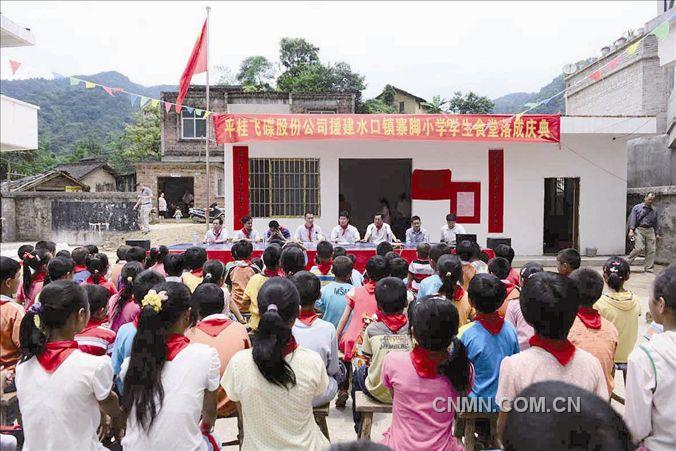 　　5月15日，地处大山深处的广西贺州市平桂管理区水口镇寨脚村里欢天喜地，热闹非凡。由中国有色集团（广西）平桂飞碟股份有限公司捐资58000元兴建的学校食堂当日建成投入使用， 近百名山村小学生成为最开心的主角。　　这天，他们告别昔日中午开水泡冷饭、泡快餐面甚至饿肚子的日子，首次在学校食堂吃上了香喷喷的午餐。　　2011年重返央企的平桂飞碟公司十分注重履行社会责任，已先后投入700多万元在道路交通、人畜饮水、植树绿化等方面帮助企业周边地区的群众改善生产生活条件。    黄旭胡 罗雪兰 摄